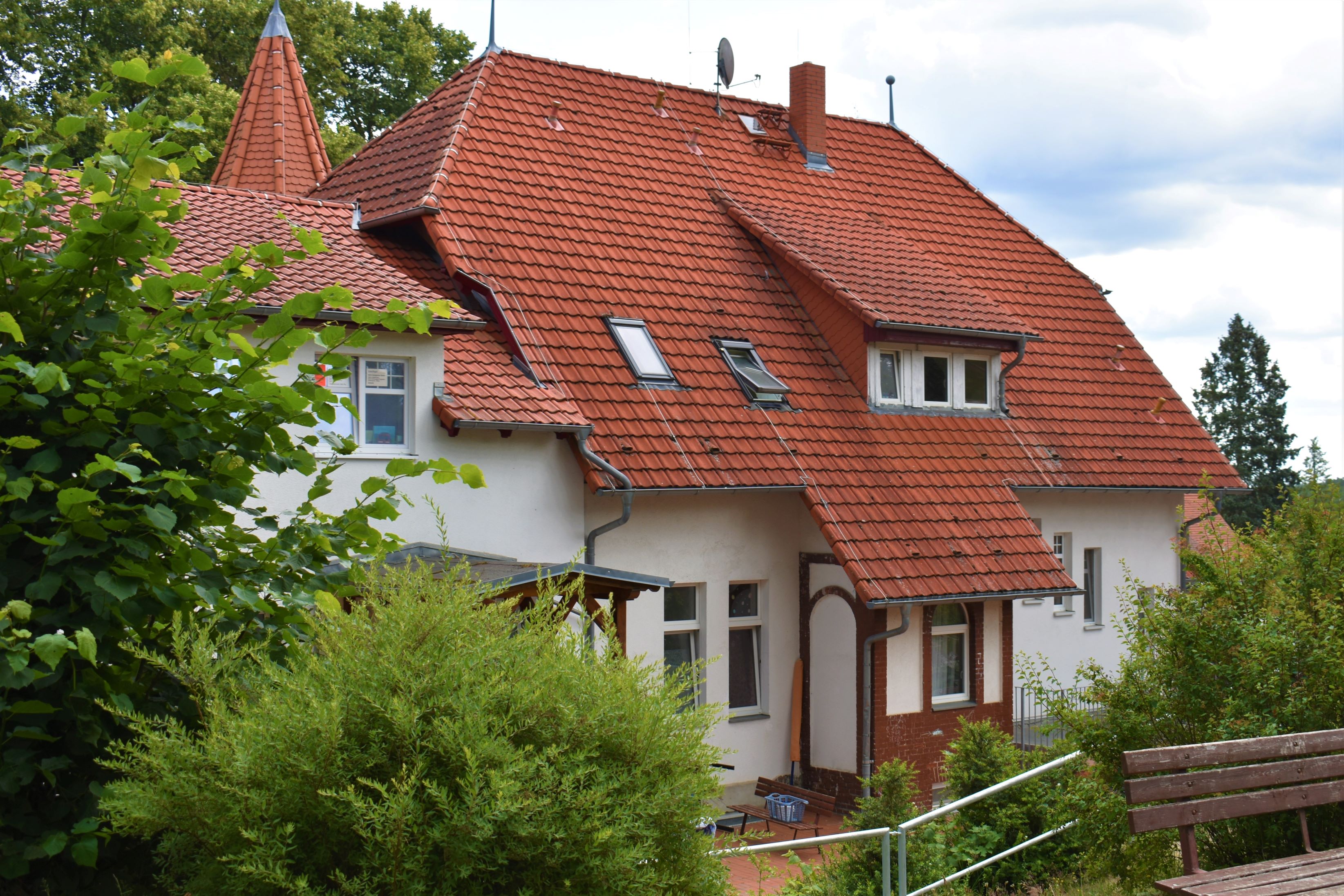 Das Gebäude der Bergvilla des ASB im Barnim inmitten einer Gartenlandschaft.