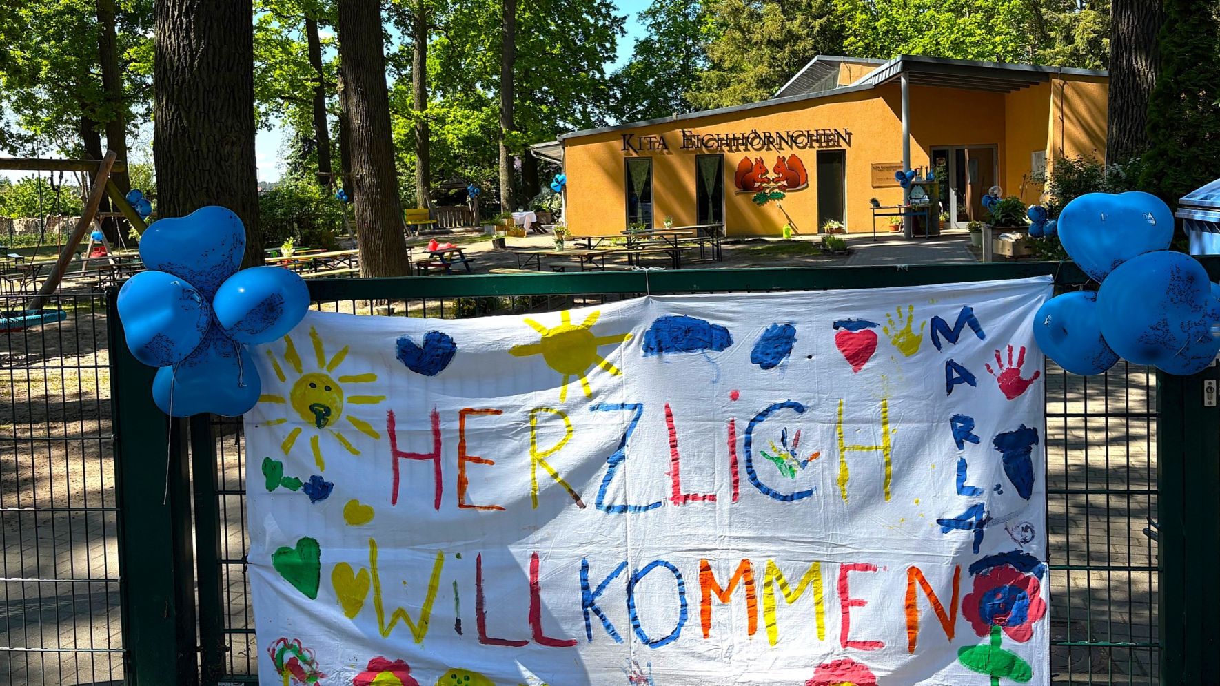Am Eingangstor unserer Kita Eichhörnchen in Zeprenschleuse hängt ein bunt bemaltes Transparent mit dem Aufdruck: Herzlich Willkommen!